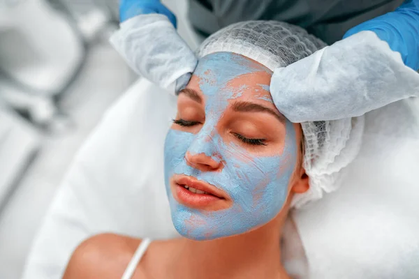 Cosmetologista Limpa Uma Máscara Descascamento Limpeza Argila Rosto Uma Jovem — Fotografia de Stock