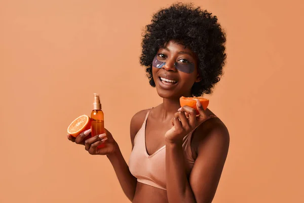African American Slim Woman Lingerie Using Eye Patches Eating Orange — Stock Photo, Image