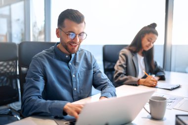 Bir grup genç iş adamı modern ofiste birlikte çalışıyor. Bilgisayarı, tableti, akıllı telefonu, defteri olan yaratıcı insanlar. Birlikte çalışan başarılı bir hipster takımı. Bağımsızlar.