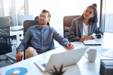 Bir grup genç iş adamı modern ofiste birlikte çalışıyor. Bilgisayarı, tableti, akıllı telefonu, defteri olan yaratıcı insanlar. Birlikte çalışan başarılı bir hipster takımı. Bağımsızlar.