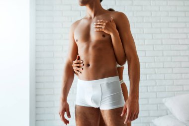 Ateşli esmer, yatak odasında erkeğinin gövdesine sarılıyor. Beyaz iç çamaşırlı seksi bir çift. Güzel ve tutkulu bir çift seks yapmadan önce nişanlanır..