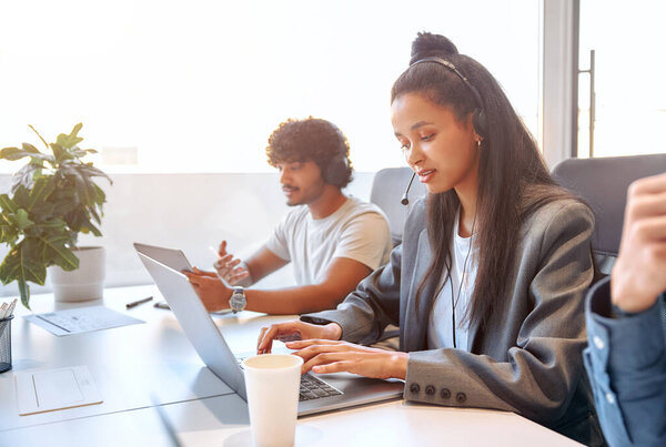 Call center staff accompanied by their team. A team of freelancers working in a coworking space in a modern office. Young employees working with headset and laptop.