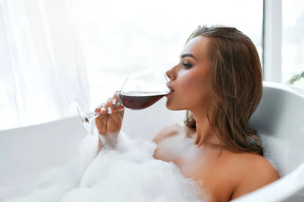 Страстная Сексуальная Женщина Принимает Расслабляющую Ванну Пеной Пьет Красное Вино — стоковое фото