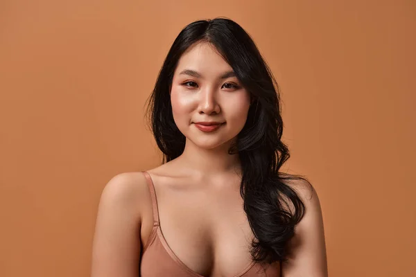 一个穿着米黄色内衣裤的年轻亚洲女人的画像 背景是米黄色的 皮肤护理 美容和温泉治疗的概念 — 图库照片