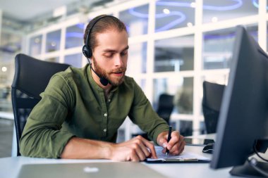 Kulaklıkla çalışan teknik destek operatörü. Çağrı merkezi operatörü olarak çalışan gülümseyen yakışıklı adam, müşteriyle konuşuyor. Video konferansı yaparken uzaktan çalışan mutlu iş adamı..