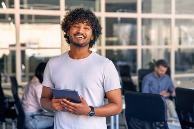Ofisinde tabletle duran ve ekibiyle çalışan genç bir işadamı. Ortak bir çalışma alanında çalışan bir grup serbest çalışan. Başarılı insanlar birlikte iş kuruyor..
