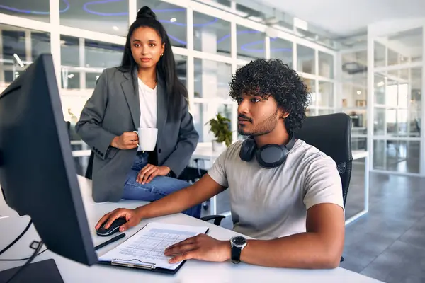 stock image Asian multiethnic man and woman freelancers discussing work and business in a modern coworking office while sitting at a computer. Colleagues are conferring at the expense of a startup.