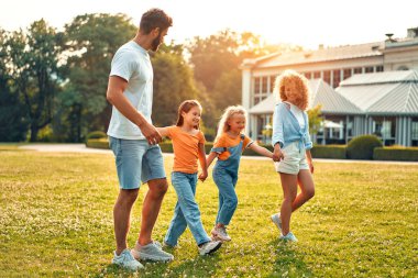 Mutlu bir aile babası, anne ve iki çocuk. Güneşli bir günde parkta yürüyen, koşan ve oynayan kız kardeşler. Birlikte eğleniyorlar ve tatil günlerinde doğanın tadını çıkarıyorlar..