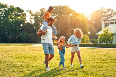 Mutlu bir aile babası, anne ve iki çocuk. Güneşli bir günde parkta yürüyen, koşan ve oynayan kız kardeşler. Birlikte eğleniyorlar ve tatil günlerinde doğanın tadını çıkarıyorlar..