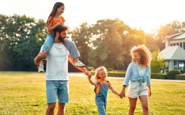 Mutlu bir aile babası, anne ve iki çocuk. Güneşli bir günde parkta yürüyen, koşan ve oynayan kız kardeşler. Birlikte eğleniyorlar ve tatil günlerinde doğanın tadını çıkarıyorlar..