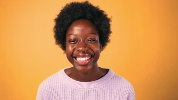 Αφροαμερικανή Νεαρή Γυναίκα Αφρο Χτένισμα Στέκεται Πουλόβερ Ένα Φωτεινό Πορτοκαλί — Αρχείο Βίντεο