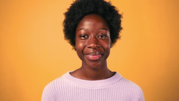 오렌지 배경과 미소에 스웨터에 아프리카 스타일 아프리카계 미국인 — 비디오