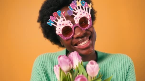 오렌지 배경에 스웨터에 편지와 안경을 아프리카 스타일 아프리카계 미국인 — 비디오