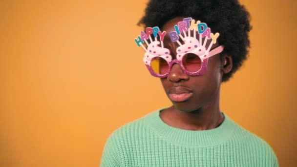 아프리카계 미국인 아프로 스타일 케이크와 오렌지 배경에 스웨터에 편지와 안경을 — 비디오