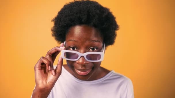 Afroamerykańska Młoda Kobieta Fryzurą Afro Okularami Stoi Swetrze Jasnopomarańczowym Tle — Wideo stockowe