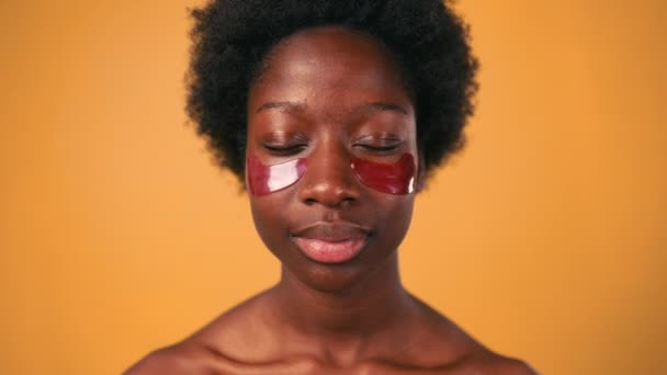 아침에 머리를 아프리카 미국인젊은 여자는 오렌지 배경에 보안경을 사용하여 물기를 — 비디오