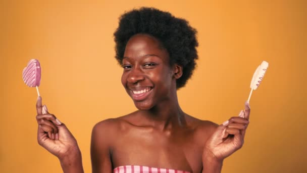 Afroamerykańska Młoda Kobieta Afro Włosy Trzymając Różowe Cukierki Serca Odizolowane — Wideo stockowe