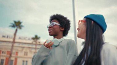 Afro-Amerikalı ve Asyalı kadınlar, kız arkadaşlar, hippiler, sokaklarda yürüyüp konuşuyorlar. İki arkadaşımla buluşacağım. Arkadaşlar izin günlerinde eğlenir..