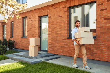 Elinde bir yığın kutu olan çekici genç bir adam onları yeni evine getiriyor. Kiralamak ve bir ev almak. Taşınma konsepti.