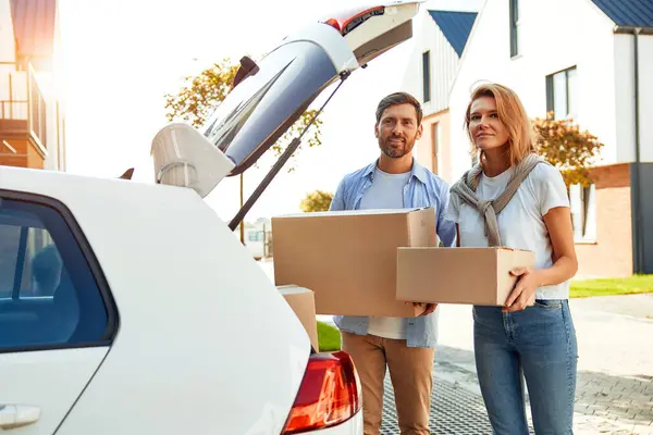 Young Married Couple Unloads Boxes Things Car Carries Them New — Stock Photo, Image
