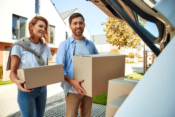 Genç evli bir çift arabadan kutularca eşya boşaltıp onları yeni bir eve taşır. Kiralamak ve bir ev almak. Taşınma konsepti.