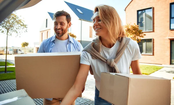 Genç evli bir çift arabadan kutularca eşya boşaltıp onları yeni bir eve taşır. Kiralamak ve bir ev almak. Taşınma konsepti.