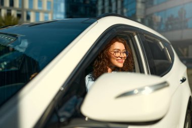 Yeni arabasını süren güzel, mutlu, genç bir kadın. Bir araba alıp kiralamak. Seyahat, turizm, eğlence..