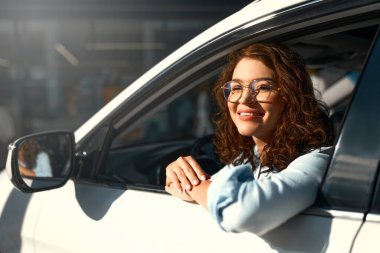 Yeni arabasını süren güzel, mutlu, genç bir kadın. Bir araba alıp kiralamak. Seyahat, turizm, eğlence..