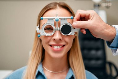 Optik atölyesindeki kadın göz testi yapıyor. Optimetrist klinikteki kadın hasta için görüş testi yapıyor. Oftalmoloji ve göz düzeltmesi.
