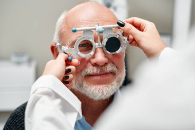 Görüş testi, tanılama ve görüş testi sırasında olgun bir erkeğe danışma. Göz bakımı, optometri hizmetleri ve görüş testi. Eleştiri kavramı, hizmet reklamları.