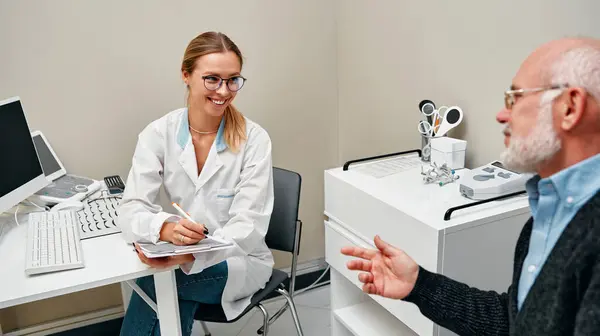 Женщина Офтальмолог Обсуждает Диагноз Зрелым Пациентом Сидя Компьютером Офтальмологической Клинике — стоковое фото