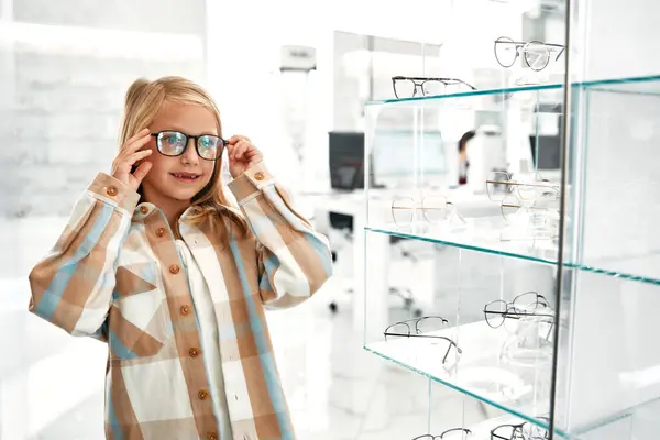 プロの店に立っている光学グラスのかわいい女の子 ビジョン修正と眼科 — ストック写真