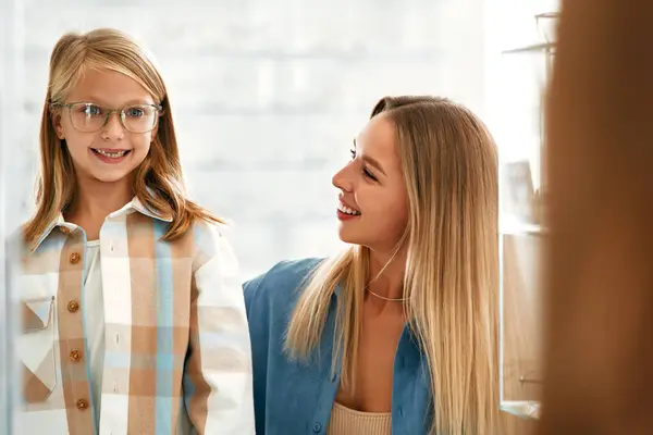 子供の娘と一緒にプロの店で光学メガネを選ぶ ビジョン修正と眼科 — ストック写真