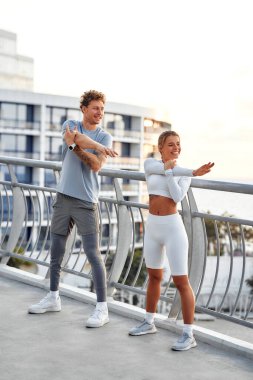 Bir çift dışarı çıkmadan önce ısınıyor. Sabah egzersizi ve koşu. Spor ve eğlence, aktif yaşam tarzı.