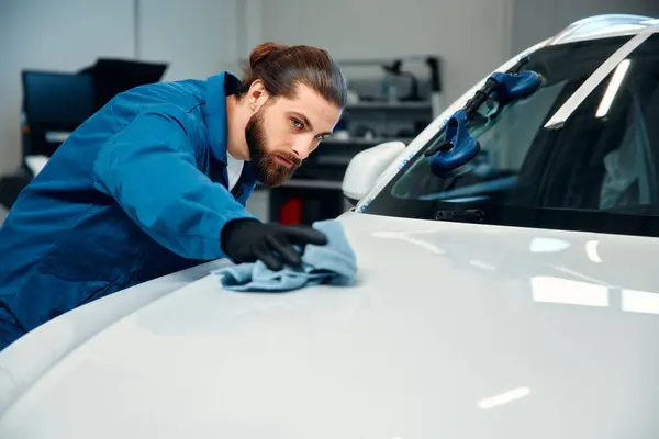 stock image Car detailing - the man holds the microfiber in hand and polishes the car. A man cleaning car with microfiber cloth, car detailing (or valeting) concept.