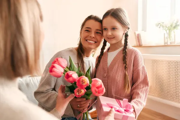 Granddaughter Daughter Congratulating Grandmother Giving Her Flowers Gift While Sitting — Stock Photo, Image