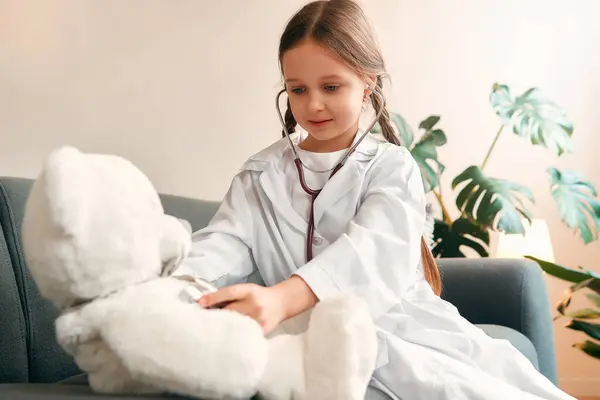 Menina Criança Vestido Médico Com Estetoscópio Tratando Urso Pelúcia Sentado — Fotografia de Stock