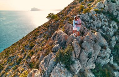 Calpe Comunidad Autonoma de Valencia, İspanya. Seyahat ve turizm. Okyanus kıyısındaki bir şehrin uçurumunda birbirini seven bir çift turist..