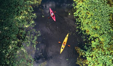 Ukrayna 'nın Kiev kentindeki Dinyeper Nehri' ndeki birçok su zambağı arasında kayak yapan turistlerin insansız hava aracı görüntüsü. Turizm ve dinlenme.