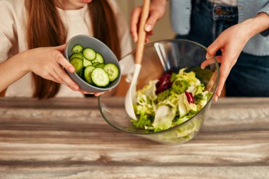 Sıcak ve misafirperver bir mutfakta, bir anne ve kız lezzetli bir salatayı hazırlarken, kaliteli zaman geçirmenin ve anıların tadını çıkarırken birbirlerine bağlanırlar.