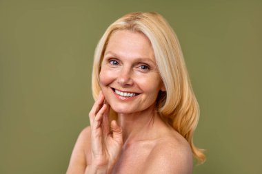 Güzel, olgun, orta yaşlı, parlak tenli, zeytinli bir kadın. Olgun yaşlı kadın yakın çekim. Sağlıklı yüz derisi, orta yaşlı cilt bakımı kozmetik ürünleri, kozmetoloji konsepti