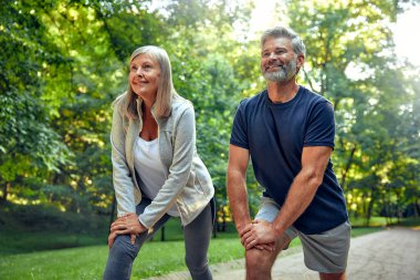 Bir çift aktif son sınıf öğrencisi, yemyeşil bir parkta, eğlenceli hareketleri ve doğa ile bağlantıları sayesinde sağlıklı bir yaşam tarzı, sağlık ve zindelik sağlıyorlar.