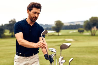 Odaklanmış bir golfçü kulübünü özenle verimli, canlı bir golf sahasında seçiyor. Doğanın ortasında yüksek kaliteli golf ekipmanları ve açık hava spor ekipmanlarını etkin bir şekilde tanıtmak için ideal bir ortam.