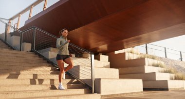 Fiziksel olarak zinde bir birey güvenli bir şekilde açık hava merdivenlerinden iniyor, canlı bir şehir ortamında aktif bir egzersiz yapıyor, manzarayı güzelleştiren etkileyici bir köprü ile tamamlanıyor.