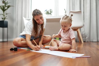 Sevgi dolu bir anne ve tapılası bebeğinin birlikte yaratıcı sanat zamanlarına daldığı, harika bir bağ, neşe ve hayal gücünü geliştirdiği keyifli bir sahne.