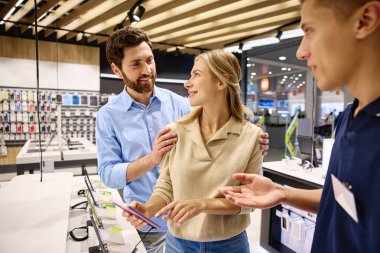 Yoğun bir elektronik mağazasında keyifli bir alışveriş deneyimi, birkaç danışman, enerjik ve dost canlısı bir satış temsilcisini en son akıllı telefon teknolojileri trendleri ve yenilikleri hakkında aydınlatır.