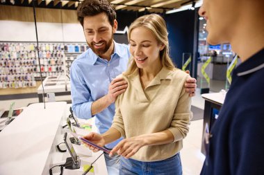 Yoğun bir elektronik mağazasında keyifli bir alışveriş deneyimi, birkaç danışman, enerjik ve dost canlısı bir satış temsilcisini en son akıllı telefon teknolojileri trendleri ve yenilikleri hakkında aydınlatır.