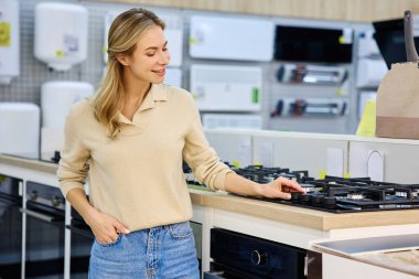 Genç bir kadın, modern bir yaşam tarzını tamamlayan çağdaş yemek malzemeleri ve yenilikçi ev tasarımı unsurlarına olan gerçek ilgisini sergileyerek çeşitli mutfak aletlerini aktif olarak keşfediyor.