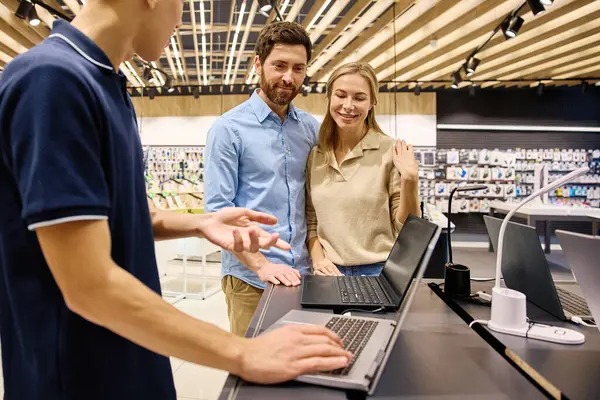 Bir çift, teknoloji mağazasında çok arkadaş canlısı ve bilgili bir satıcıya bağlanıp son satın alma kararını vermeden önce sergilenen çok çeşitli dizüstü bilgisayarları keşfediyor.