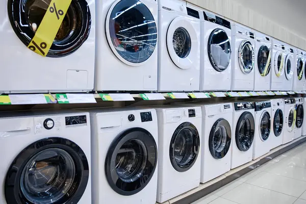 Şık, şık, modern çamaşır makineleri bir perakende mağazasında güzelce sergileniyor, cazip promosyon fiyatlarının yanı sıra çeşitli eşsiz tasarımlar sergiliyor.